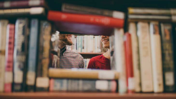 chica hablando con chico en la biblioteca