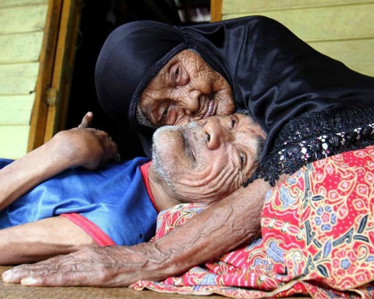 mujer anciana abraza a hombre en el suelo 