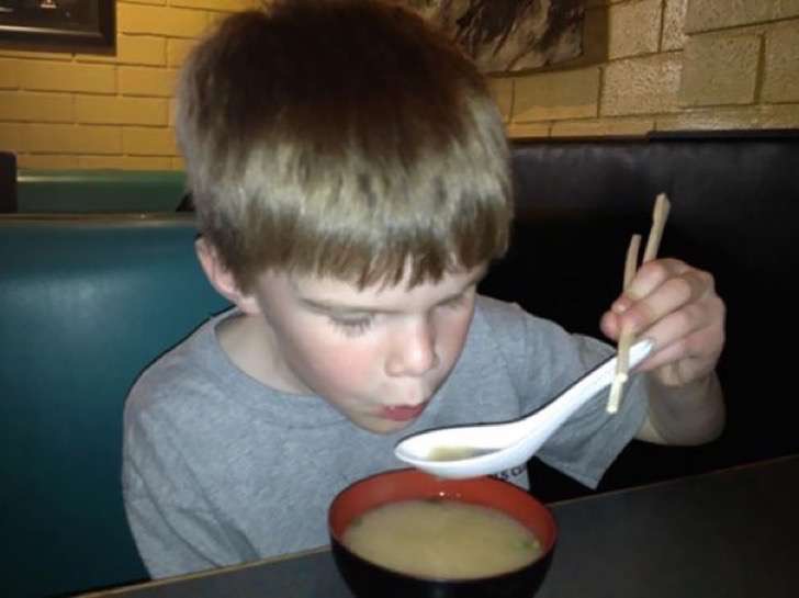 niño comiendo con palos y cuchara 