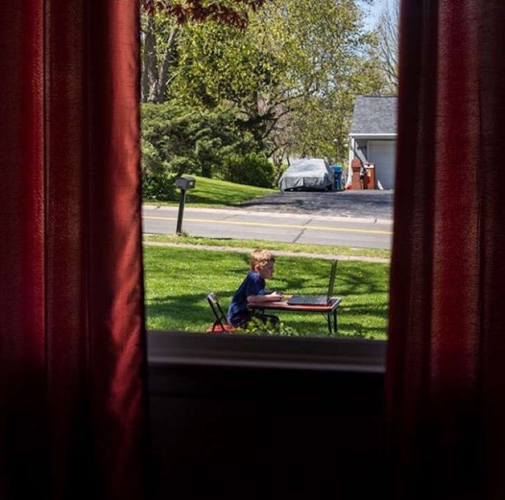 niño jugando con laptop en el jardin