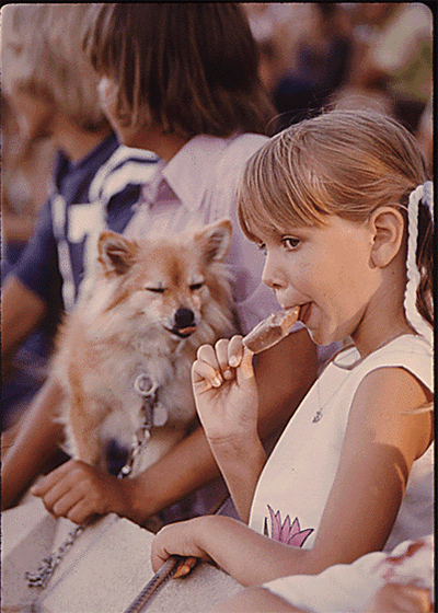 gif niña compartiendo su paleta con un perrito