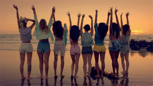 gif mujeres con los brazos arriba en la playa