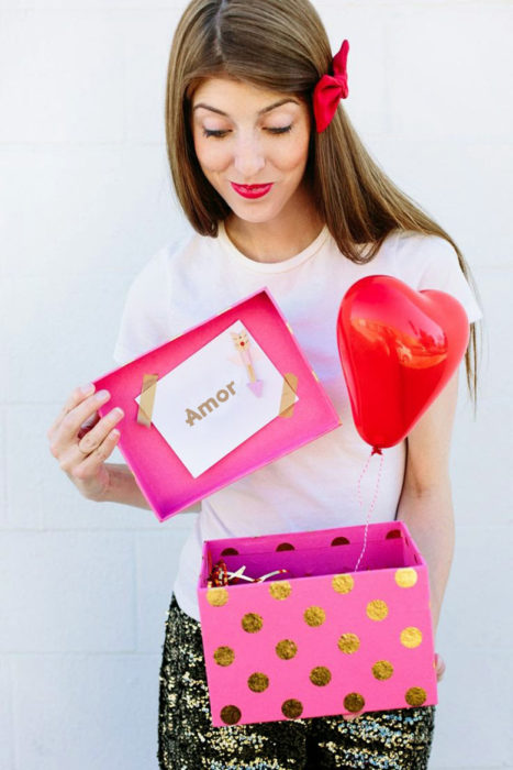 chica con una caja de regalo y globos