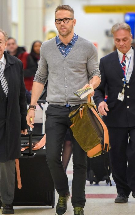 hombre con lentes caminando en aeropuerto 