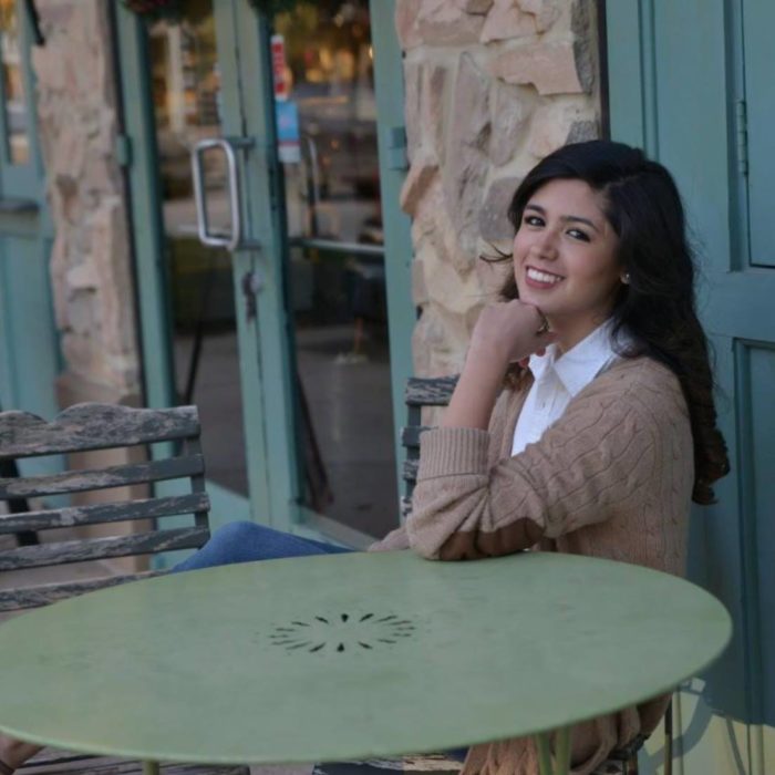 chica sonriendo sentada en una mesa 