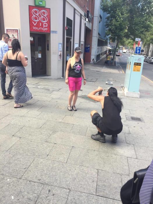 hombre agachado tomando foto a chica rubia 