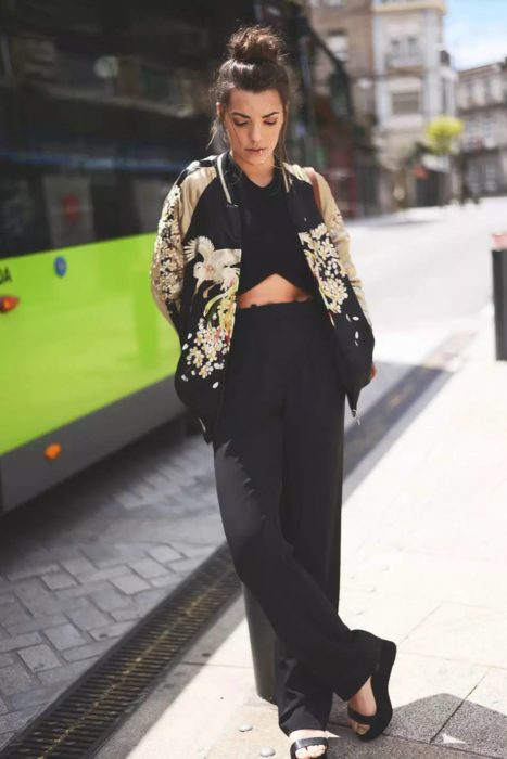 Chica usando un crop top, pantalón de talle alto y bomber 