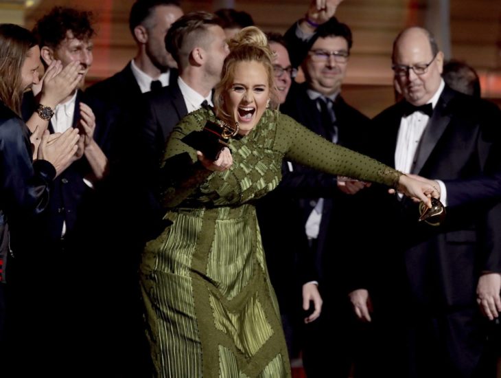 mujer rubia en vestido verde recibiendo premio 