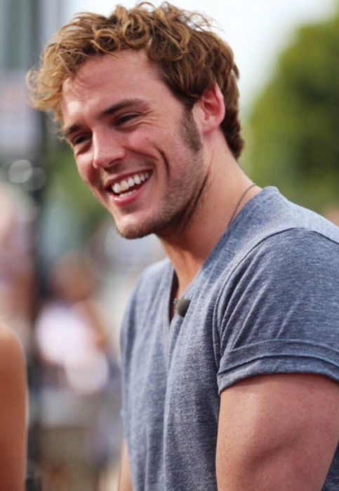 hombre con playera gris sonriendo