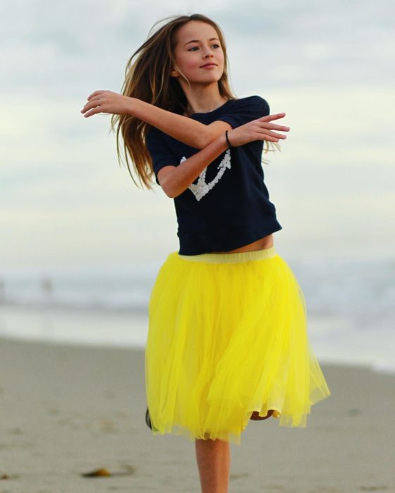 Kristina pimenova en la playa con falda amarilla