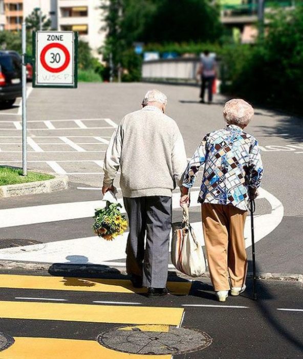 Pareja de abuelitos tomados de las manos caminando por el centro