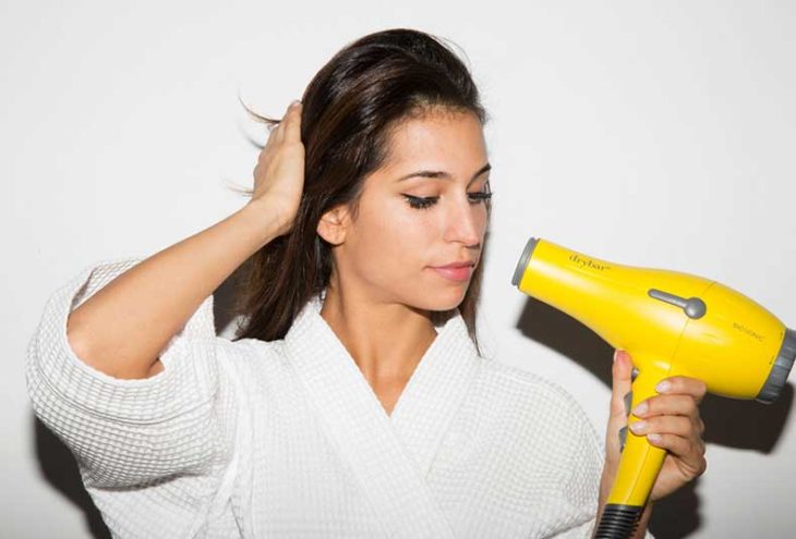 chica secando su cabello