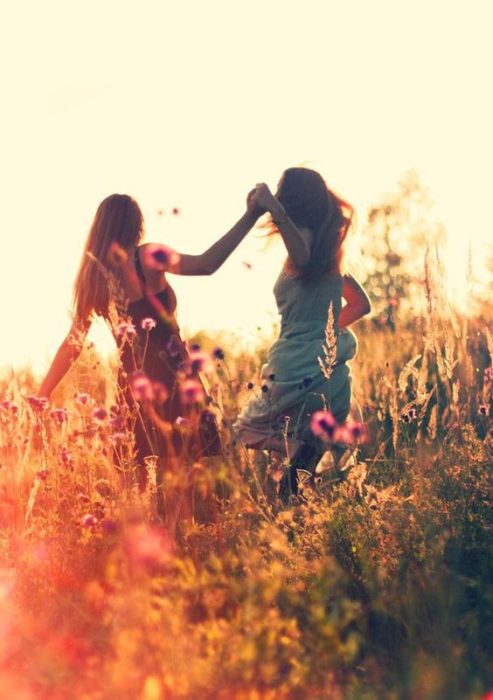 amigas tomadas de la mano por el campo