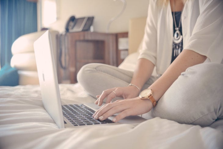 chica con su computadora en la cama