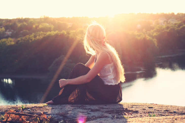 chica viendo al sol en el lago