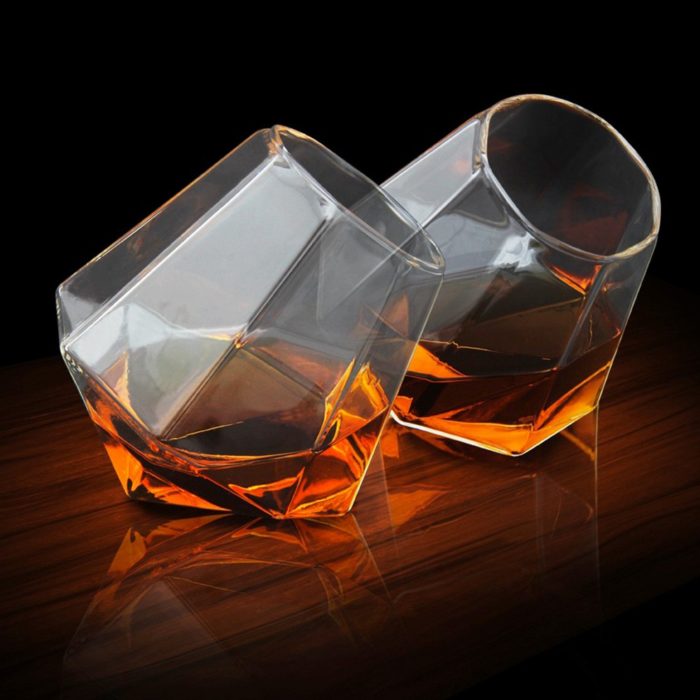 dos copas de vidrio en forma de diamante con alcohol