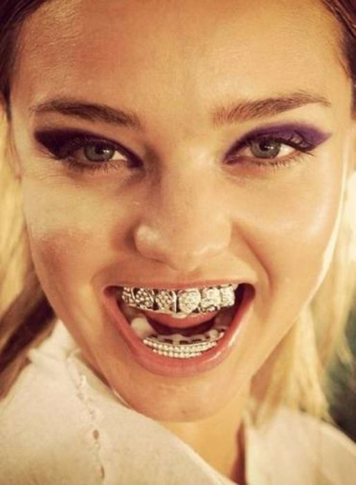 mujer sonriendo con joyas en sus dientes 