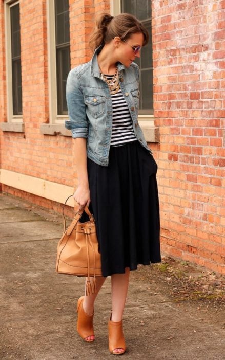 mujer con blusa de rayas y chamarra de mezclilla y falda
