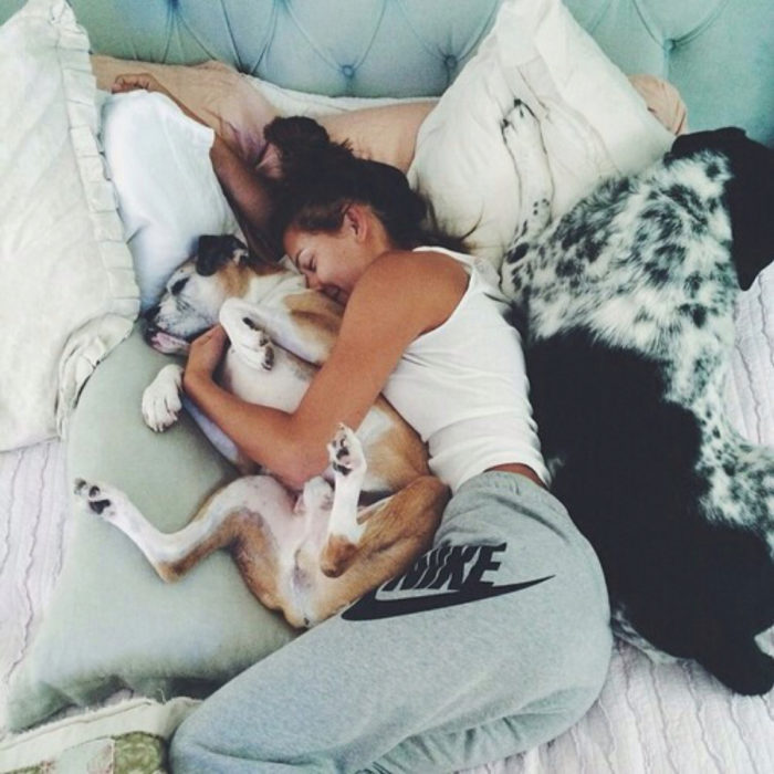 mujer con su perro en la cama