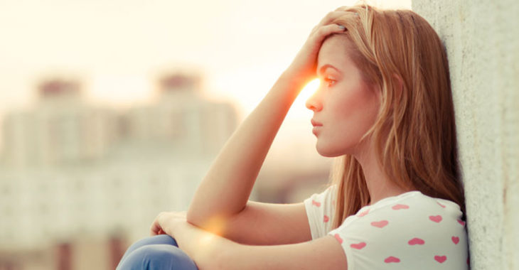 mujer sentada a contra luz pensando