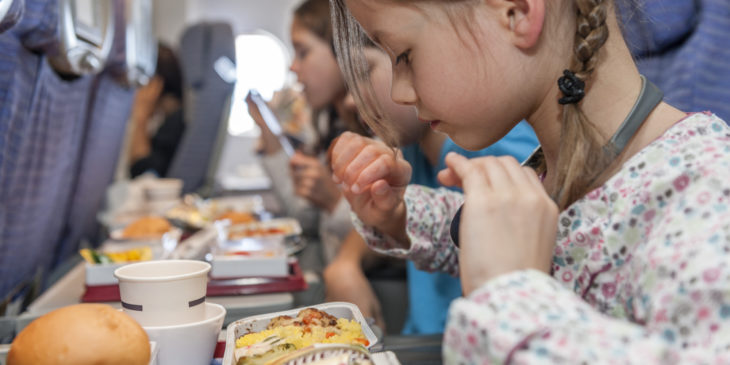 niña comiendo en el avión