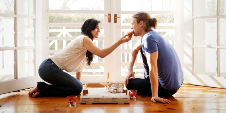 pareja comiendo pizza en el piso
