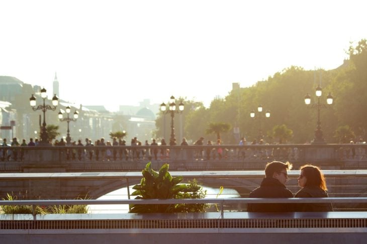 pareja sentada conversando frente a la ciudad