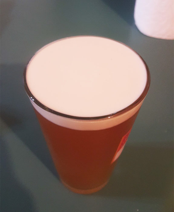 Espuma de la cerveza en perfecta simetría con un vaso