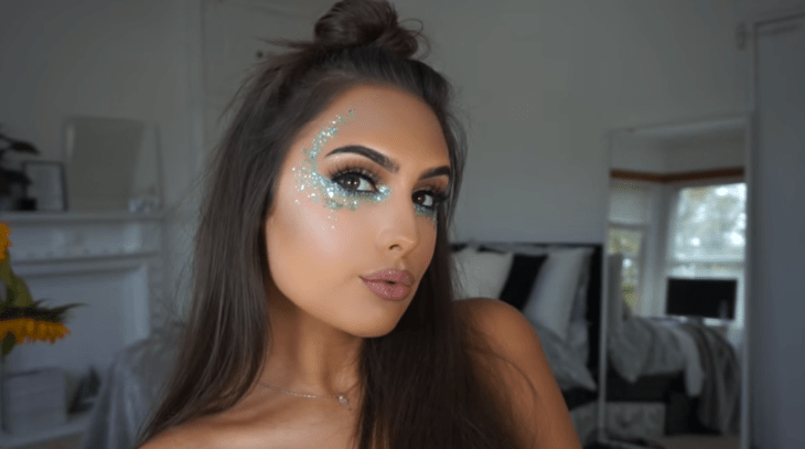 mujer morena con maquillaje verde de brillos 