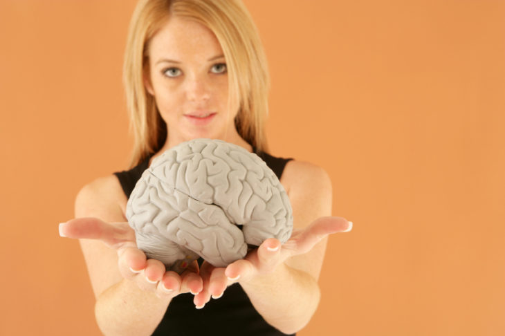 mujer rubia con cerebro en sus manos 