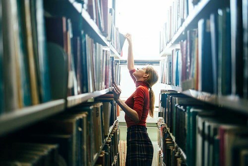 Chica en una biblioteca estudiando 