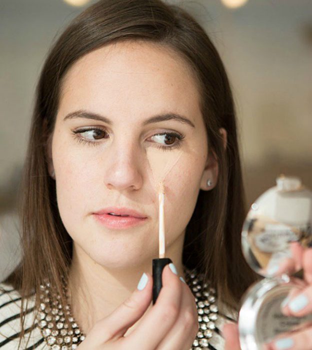 Chica aplicando maquillaje en sus pomulos 