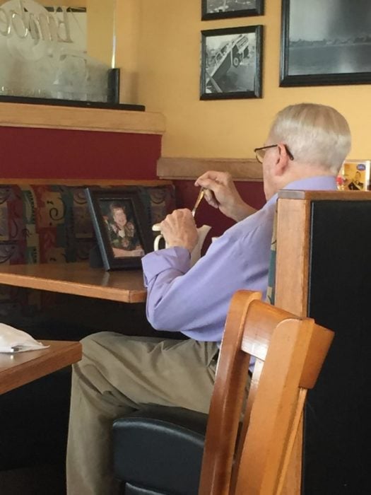 señor con foto de esposa en restaurante