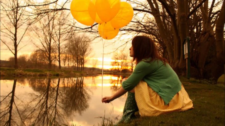 chica con globos amarillos