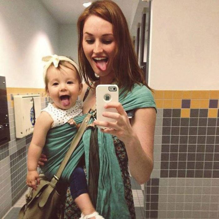 madre pelirroja cargando a bebe y selfie