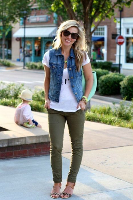 mujer con pantalon verde y chaleco de mezclilla