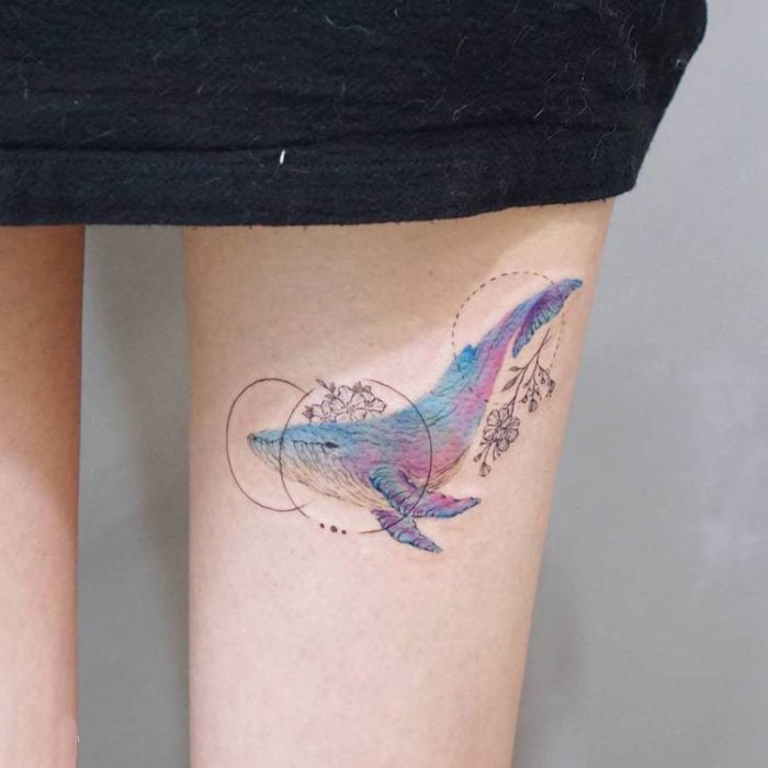 Chica con un tatuaje de ballena en la pierna 