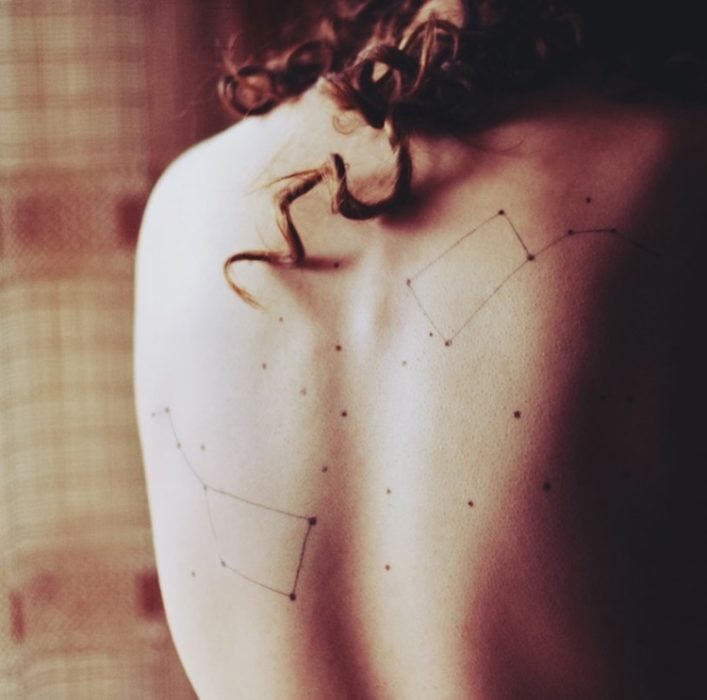 Chica con una constelación tatuada en la eslapda 