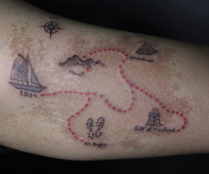 Chico con una isla tatuada en el brazo 
