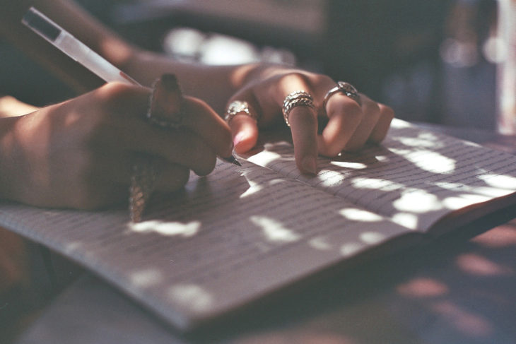 mujer escribiendo con anillos