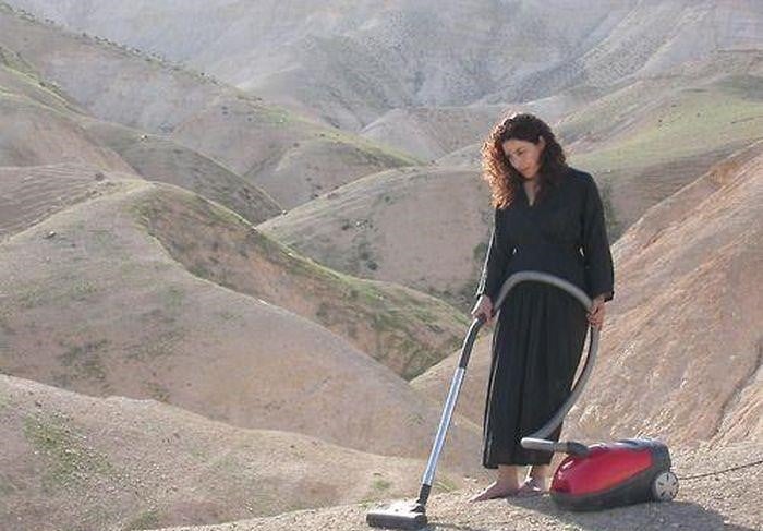 mujer con aspiradora en desierto 