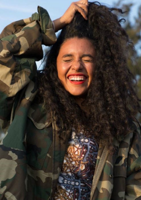 mujer sonriendo con cabello chino 