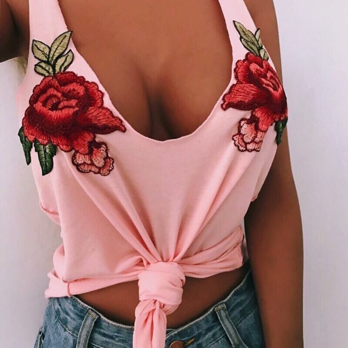 mujer con playera rosa y bordado de flores 