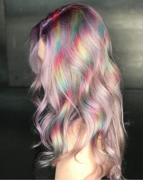 Chica de perfil con cabello largo en tono rosa oro con efecto holografico en amarillo, azul y rojo 