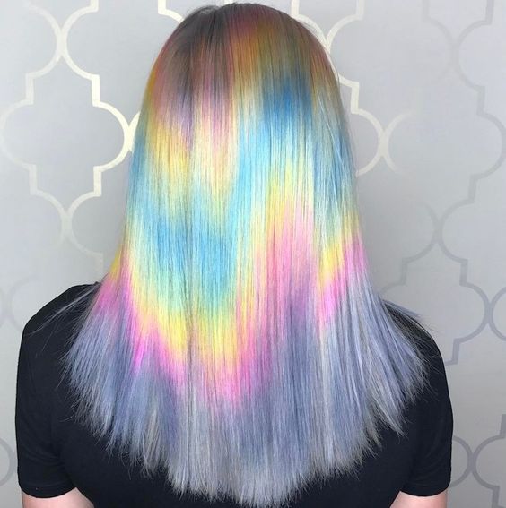Chica de espaldas mostrando su cabello con efecto holografico en tonos pastel 