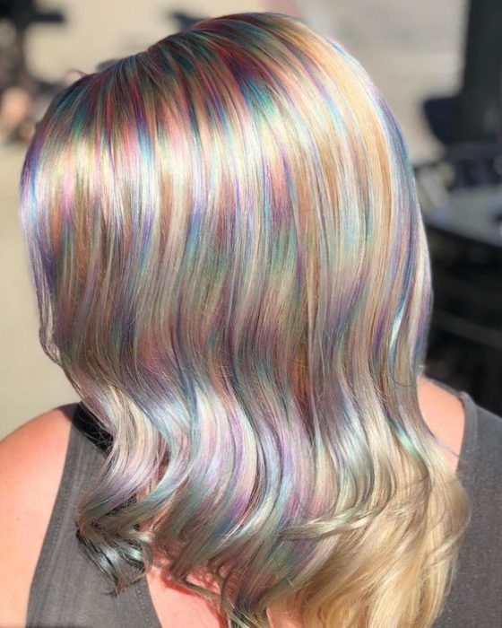 Chica con cabello rubio platinado y mechas de efecto holografico en tonos pastel 