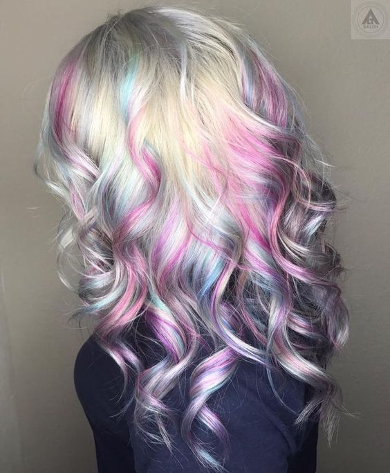 Chica de perfil mostrando su cabello con efecto holografico en tonos rosa pastel 