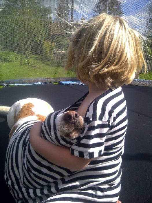 niño cubriendo a su perro 