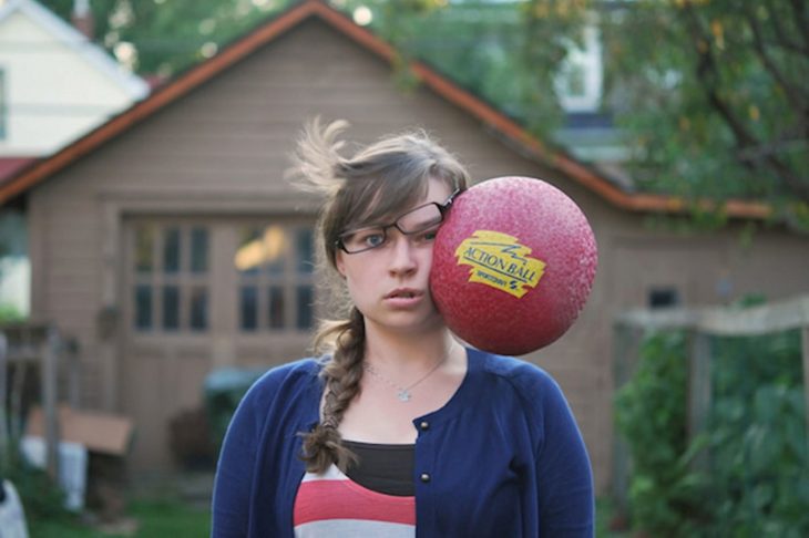 Chica con un balón en su cara 