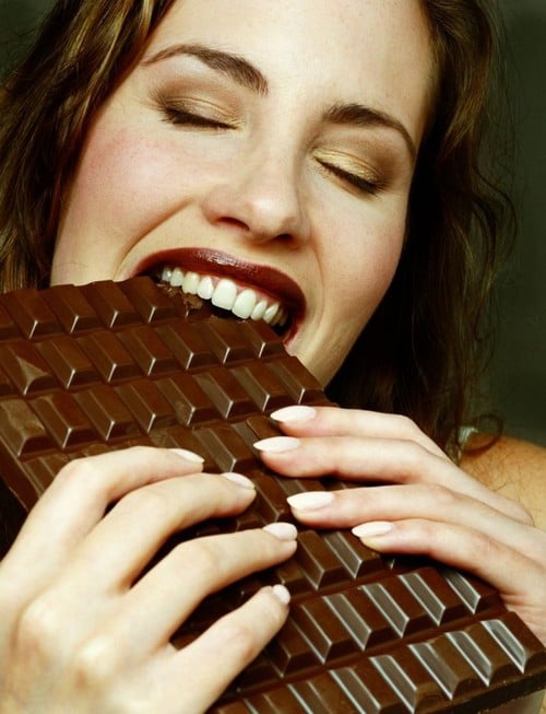 mujer comiendo chocolate negro